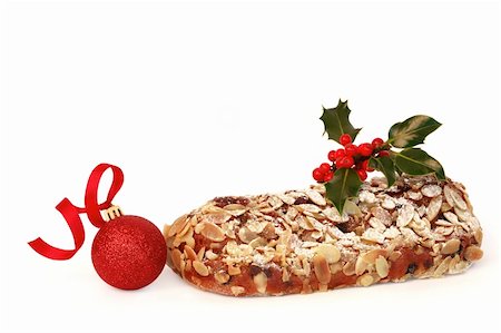 Stollen christmas cake with decorative holly leaf sprig and red berries with a sparkling red bauble, over white background. Stock Photo - Budget Royalty-Free & Subscription, Code: 400-04634184