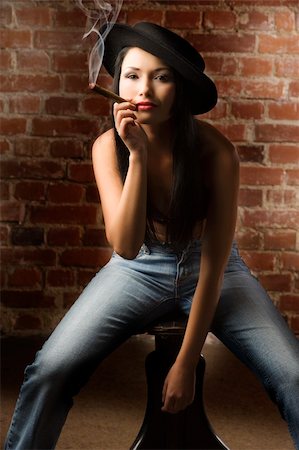 simsearch:400-04231522,k - beautiful asian girl with jeans and hat sitting and smoking a cigar Stock Photo - Budget Royalty-Free & Subscription, Code: 400-04649683