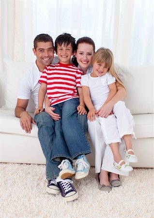 simsearch:400-04193348,k - Smiling family in living-room sitting on sofa together Stock Photo - Budget Royalty-Free & Subscription, Code: 400-04654581