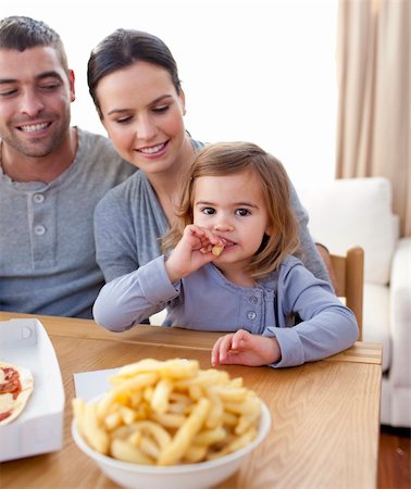 simsearch:400-04193348,k - Little girl eating fries and pizza at home with her parents Stock Photo - Budget Royalty-Free & Subscription, Code: 400-04654666
