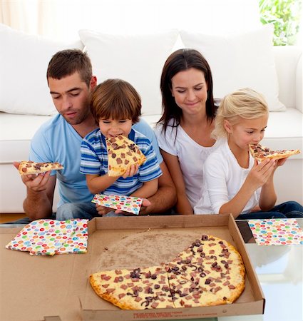 simsearch:400-04193348,k - Happy family eating pizza in living-room all together Stock Photo - Budget Royalty-Free & Subscription, Code: 400-04654737