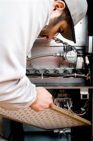 Stock image of HVAC technician replacing filter on furnace Stock Photo - Budget Royalty-Free & Subscription, Code: 400-04658663