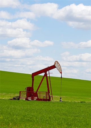 simsearch:400-04317986,k - An oil well with the pump jack in action, against a grassy, green hill & cloudy blue sky.  Located in the province of Alberta, Canada. Stock Photo - Budget Royalty-Free & Subscription, Code: 400-04658671