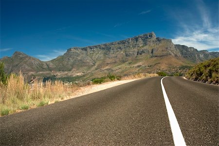 simsearch:400-04436530,k - Road leading toward Table mountain in the background with blue sky and clouds Stock Photo - Budget Royalty-Free & Subscription, Code: 400-04651147