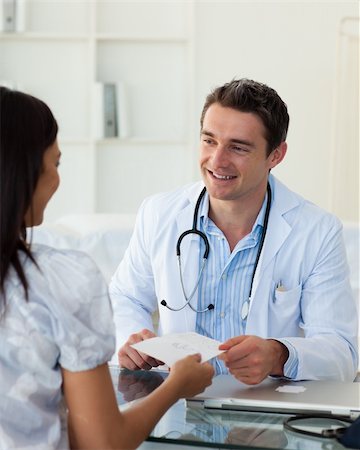 doctor consulting patient tablet - Smiling doctor giving a prescription to his female patient during a visit Stock Photo - Budget Royalty-Free & Subscription, Code: 400-04660714