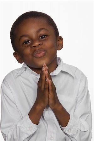 Portrait of a young boy. He is looking at the camera and his hands are pressed together as if in prayer. Vertical shot. Isolated on white. Stock Photo - Budget Royalty-Free & Subscription, Code: 400-04674027