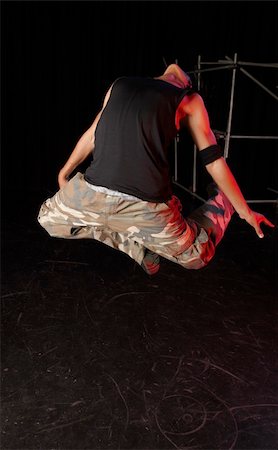 Single African male dancer dancing on the stage with black background during training session. Lit with spotlights Stock Photo - Budget Royalty-Free & Subscription, Code: 400-04676522