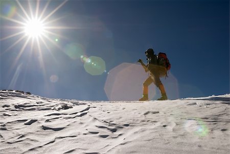 simsearch:400-05118687,k - Man of mountain climber walk in snow winter day with sun light flare. Stock Photo - Budget Royalty-Free & Subscription, Code: 400-04672770