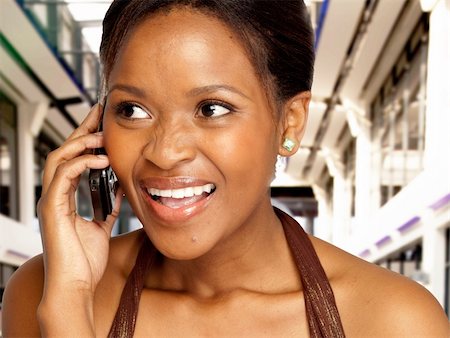 Beautiful South African black woman, speaking on cell phone with a surprised happy expression in an office environment. Stock Photo - Budget Royalty-Free & Subscription, Code: 400-04684266