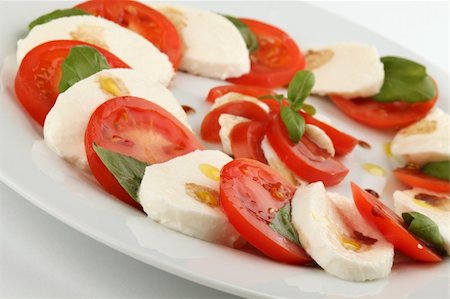 simsearch:700-01099893,k - Slices of tomatoes and mozzarella with basil leaves, olive oil and balsamic vinegar Stock Photo - Budget Royalty-Free & Subscription, Code: 400-04683866