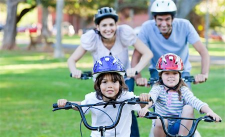 simsearch:400-05755734,k - Adorable family riding bikes in a park Photographie de stock - Aubaine LD & Abonnement, Code: 400-04696352