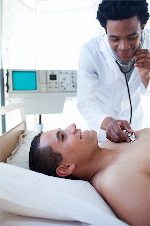 simsearch:400-05748252,k - A doctor checking the pulse on a male patient in a hospital Stock Photo - Budget Royalty-Free & Subscription, Code: 400-04699457