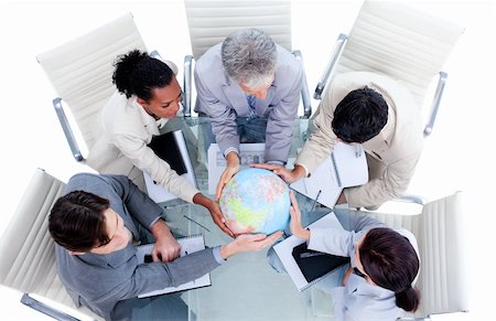 Serious international business team holding a terrestrial globe in a meeting Stock Photo - Budget Royalty-Free & Subscription, Code: 400-04690842