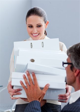 sheath - Elegant businesswoman carrying a stack of folders in the office Photographie de stock - Aubaine LD & Abonnement, Code: 400-04691058