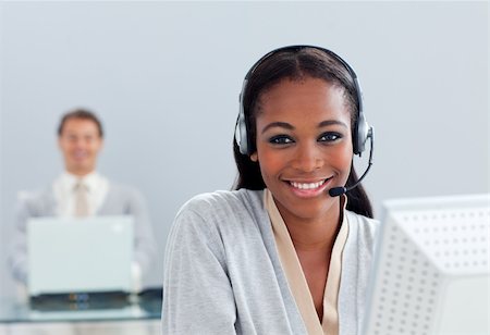 Smiling businesswoman using headset at her desk in the office Stock Photo - Budget Royalty-Free & Subscription, Code: 400-04691226