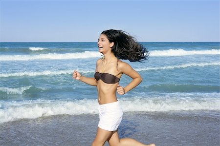 Beautiful summer indian brunette girl jumping on the blue beach Stock Photo - Budget Royalty-Free & Subscription, Code: 400-04704774