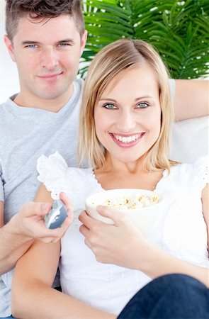 simsearch:400-04195864,k - Smiling couple looking at the camera with a present in the living-room Stock Photo - Budget Royalty-Free & Subscription, Code: 400-04704947