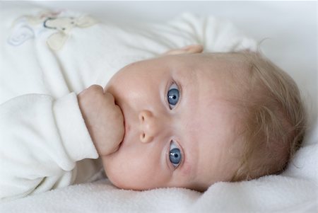 Little Baby Girl With Blue Eyes eating her fingers Stock Photo - Budget Royalty-Free & Subscription, Code: 400-04705023