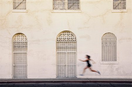 Woman runs past interesting white and tan building Stock Photo - Budget Royalty-Free & Subscription, Code: 400-04706465