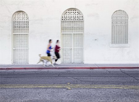 Two women running with dog along city street Stock Photo - Budget Royalty-Free & Subscription, Code: 400-04706466