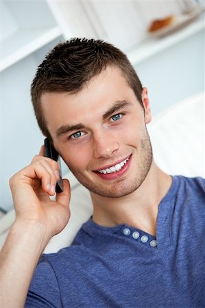 simsearch:400-04212823,k - Friendly man on phone sitting on a couch in living room Stock Photo - Budget Royalty-Free & Subscription, Code: 400-04702342