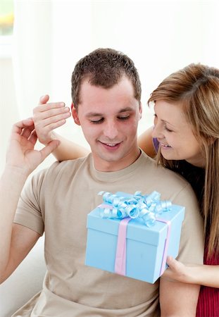 simsearch:400-04195864,k - Smiling woman giving a present to her boyfriend in the living-room Stock Photo - Budget Royalty-Free & Subscription, Code: 400-04703869