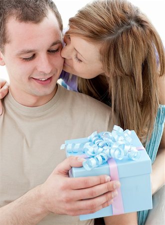 simsearch:400-04739802,k - Beautiful girlfriend giving a present and a kiss to his handsomel boyfriend against white background Stock Photo - Budget Royalty-Free & Subscription, Code: 400-04703870