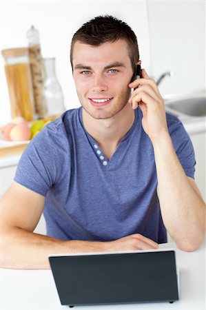 simsearch:400-04212823,k - Attractive man talking on phone looking at the camera at home Stock Photo - Budget Royalty-Free & Subscription, Code: 400-04714571