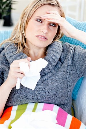feeble - Downcast woman lying on a sofa with tissues and feeling her temperature against a white background Stock Photo - Budget Royalty-Free & Subscription, Code: 400-04715319