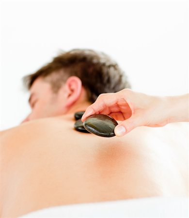 simsearch:400-04192063,k - Close-up of a positive young man having a back massage with hot stone in a spa center Stock Photo - Budget Royalty-Free & Subscription, Code: 400-04715364
