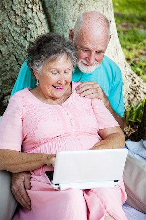 simsearch:400-04208630,k - Senior couple has fun using a netbook computer in the park. Stock Photo - Budget Royalty-Free & Subscription, Code: 400-04710136