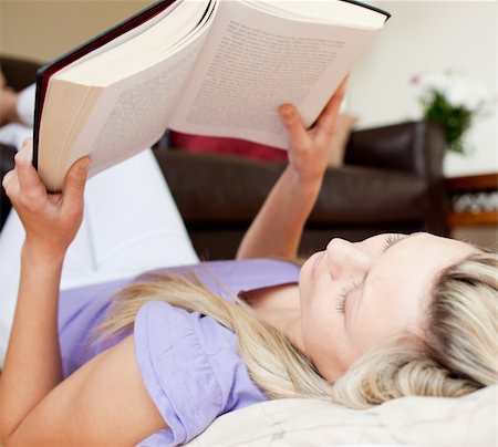 simsearch:400-04418460,k - Relaxed young woman reading a book lying on the floor in the living room Stock Photo - Budget Royalty-Free & Subscription, Code: 400-04711677