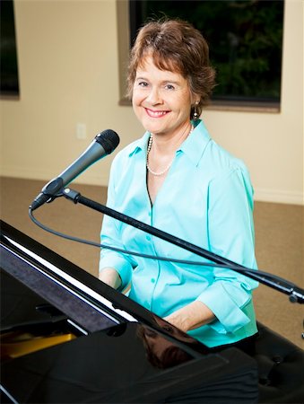 piano playing and singer - Pretty, mature piano player and singer smiles at the camera. Stock Photo - Budget Royalty-Free & Subscription, Code: 400-04728286