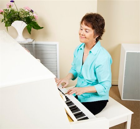 piano playing and singer - Pianist smiling as she enjoys playing the piano. Photographie de stock - Aubaine LD & Abonnement, Code: 400-04728289