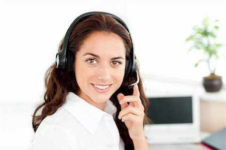 simsearch:400-05287143,k - Pretty hispanic businesswoman with headset sitting at her desk in a call center Stock Photo - Budget Royalty-Free & Subscription, Code: 400-04729475