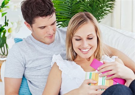 simsearch:400-04195864,k - attractive man giving a present to his girlfriend lying on the couch at home Stock Photo - Budget Royalty-Free & Subscription, Code: 400-04734909