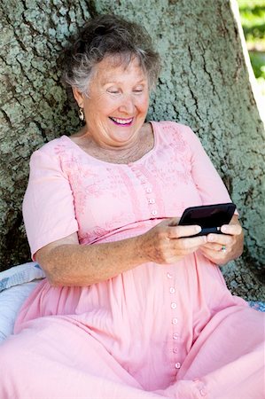 phone one person adult smile elderly - Senior woman outdoors, texting on her smart phone. Stock Photo - Budget Royalty-Free & Subscription, Code: 400-04736125