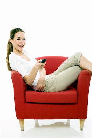simsearch:400-04398921,k - Young woman sitting on a chair with remote control on white background studio Stock Photo - Budget Royalty-Free & Subscription, Code: 400-04746025