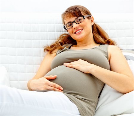 simsearch:400-04875116,k - Smiling beautiful pregnant woman lying on sofa at home and holding her belly. Stock Photo - Budget Royalty-Free & Subscription, Code: 400-04747894