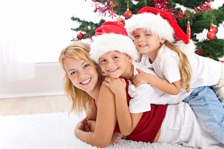 Happy christmas people heap - woman and kids laying in front of the decorated tree Foto de stock - Super Valor sin royalties y Suscripción, Código: 400-04749289