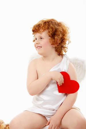 Small happy cupid sits with heart in a hand, isolated Stock Photo - Budget Royalty-Free & Subscription, Code: 400-04756930