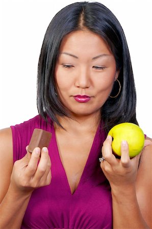 simsearch:400-05106591,k - A woman trying to decide whether or not to eat healthy Stock Photo - Budget Royalty-Free & Subscription, Code: 400-04750969
