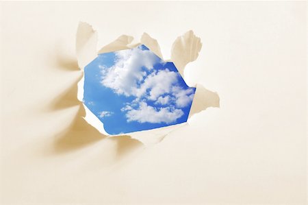 environmental impact - cloudy sky behind paper hole showing freedom Stock Photo - Budget Royalty-Free & Subscription, Code: 400-04764902