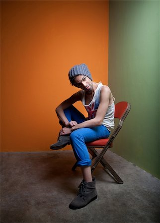 Handsome young man in graphic tea and jeans sitting in chair Stock Photo - Budget Royalty-Free & Subscription, Code: 400-04768682