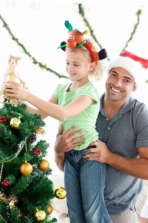 Cute little girl decorating the christmas tree with her father at home Stock Photo - Budget Royalty-Free & Subscription, Code: 400-04769409