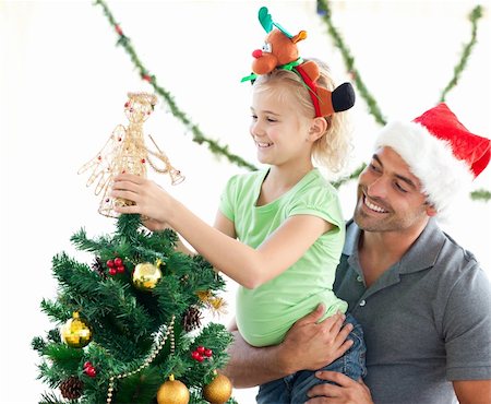 Cute little girl decorating the christmas tree with her father at home Stock Photo - Budget Royalty-Free & Subscription, Code: 400-04769410