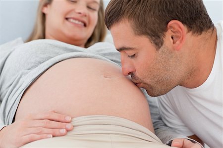 pregnant women kissing - Close up of a future dad kissing the belly of his wife lying on the bed Stock Photo - Budget Royalty-Free & Subscription, Code: 400-04769502