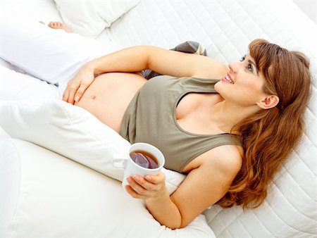 simsearch:400-04875116,k - Smiling beautiful pregnant woman relaxing on sofa at home and  holding cup of tea in hand Stock Photo - Budget Royalty-Free & Subscription, Code: 400-04762782