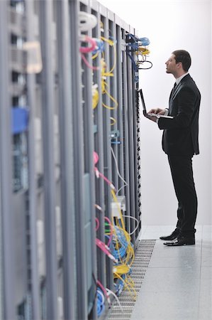 simsearch:400-05881495,k - young engeneer business man with thin modern aluminium laptop in network server room Stock Photo - Budget Royalty-Free & Subscription, Code: 400-04779223