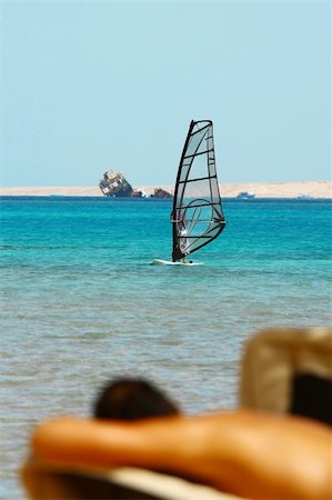 simsearch:400-03992760,k - Man tans on windsurfer, blue sea and transparent sail background Stock Photo - Budget Royalty-Free & Subscription, Code: 400-04783058